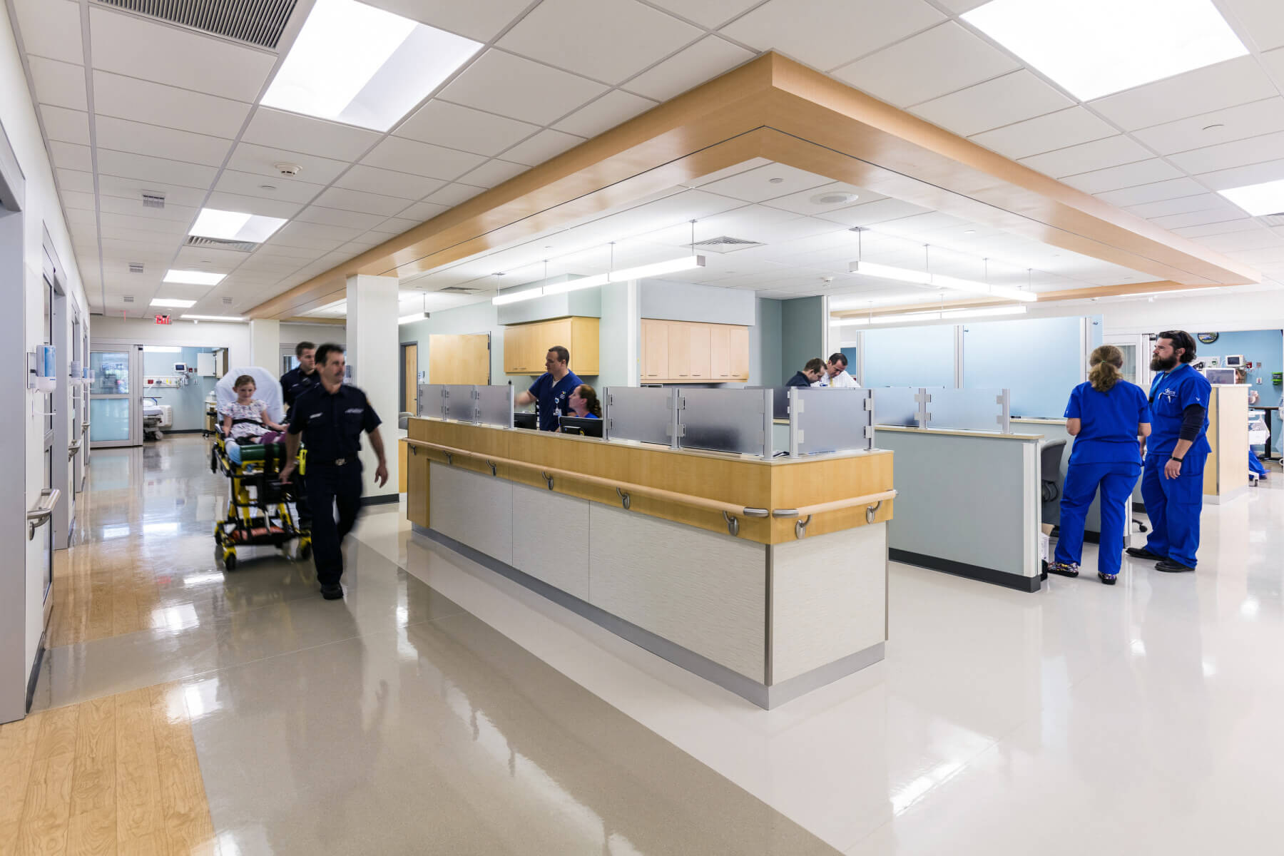 a patient on a gurney being wheeled down a corridor