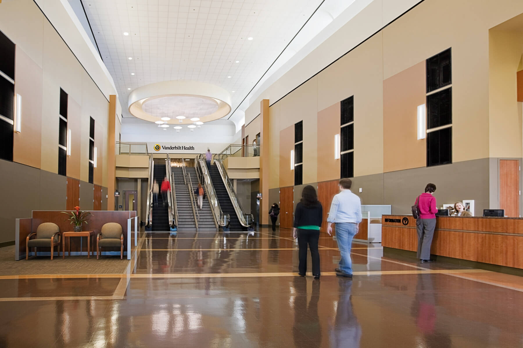 people walk through the lobby and check in desk before going up or down escalators