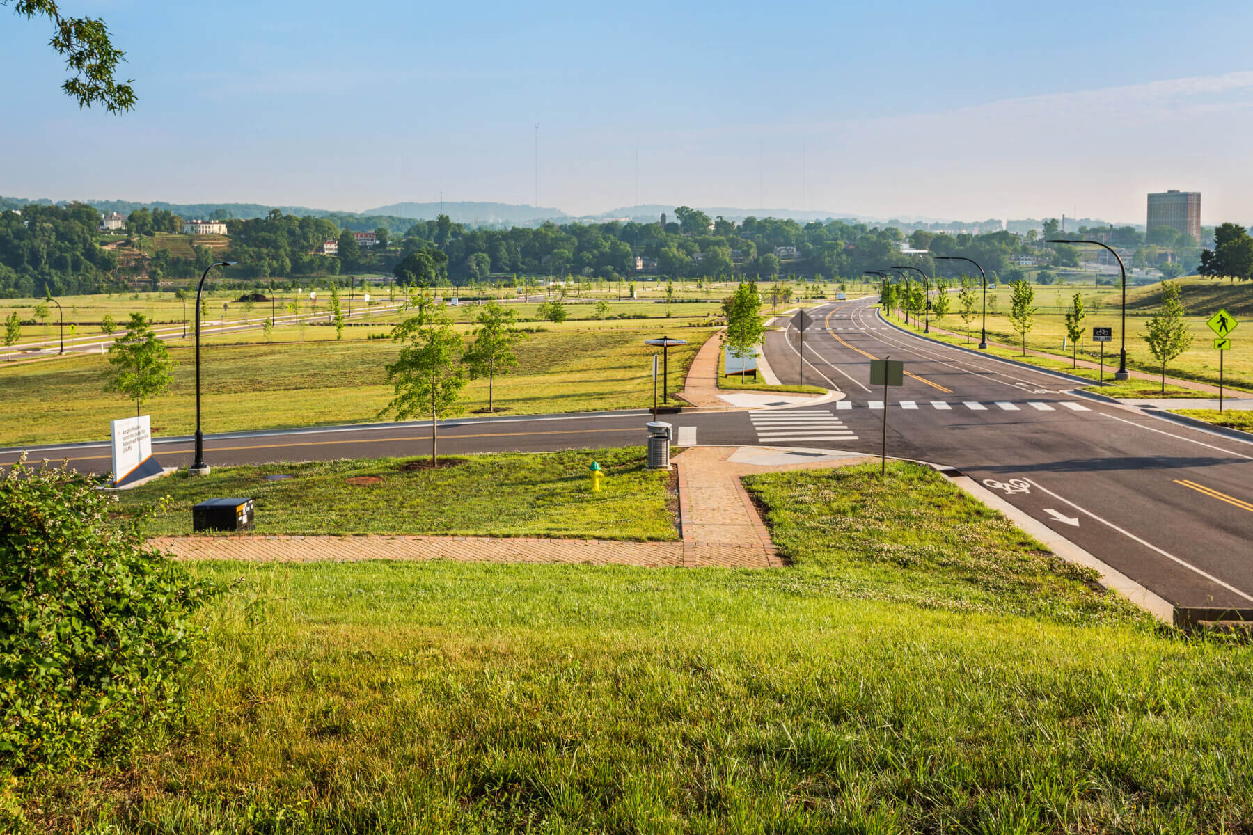 a road with grass and trees in the background