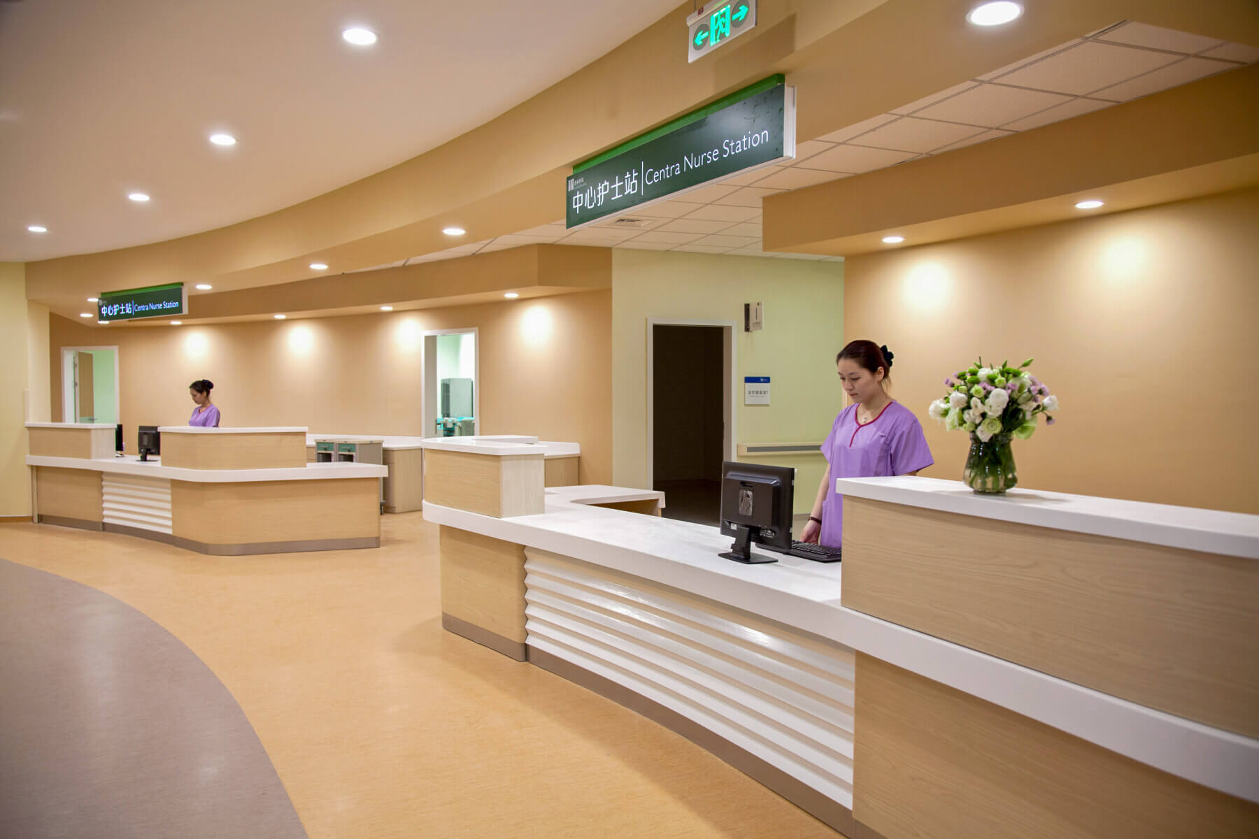 two nurses at separate nurse stations