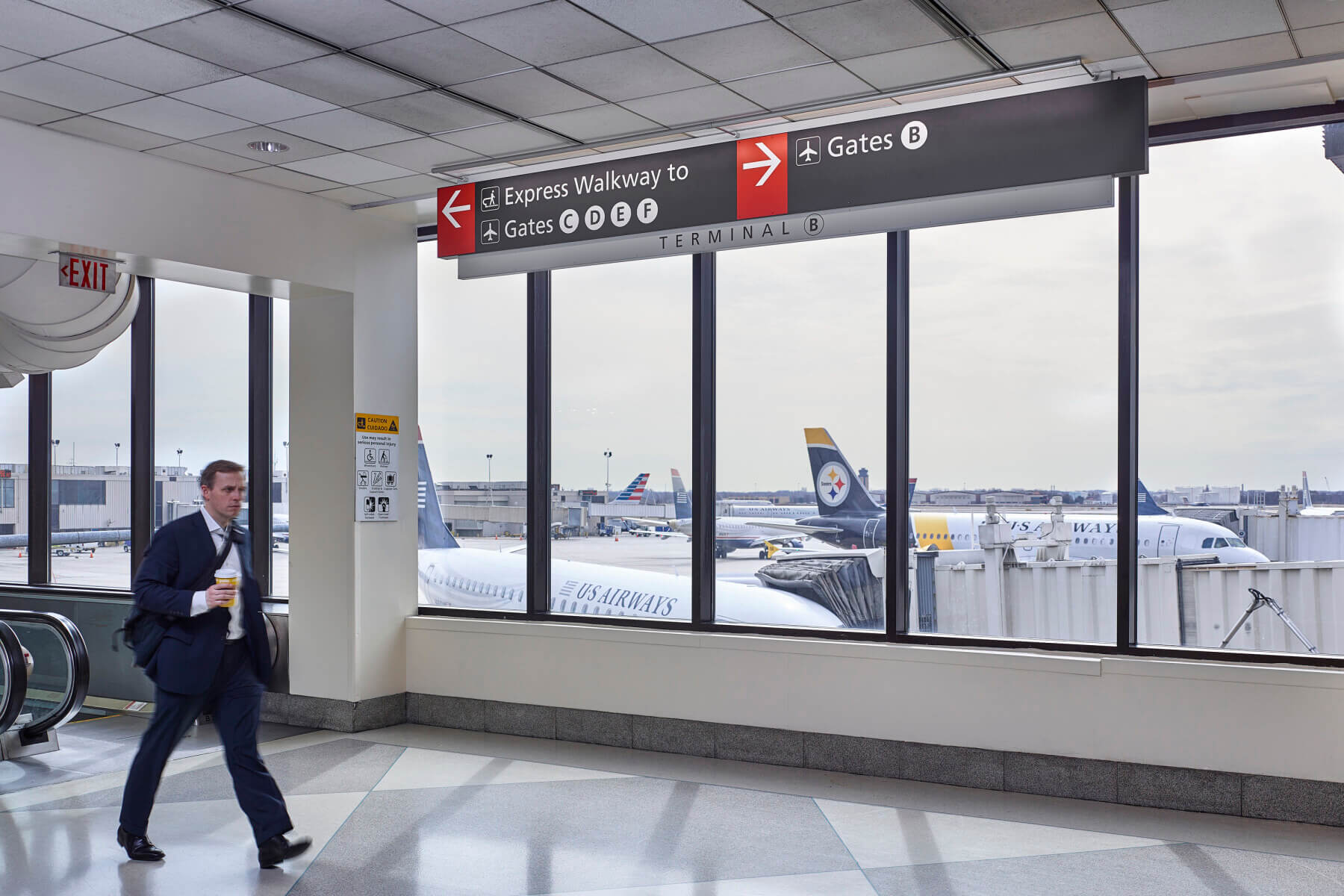 a man walking through the concourse in terminal B at Philadelphia International Airport