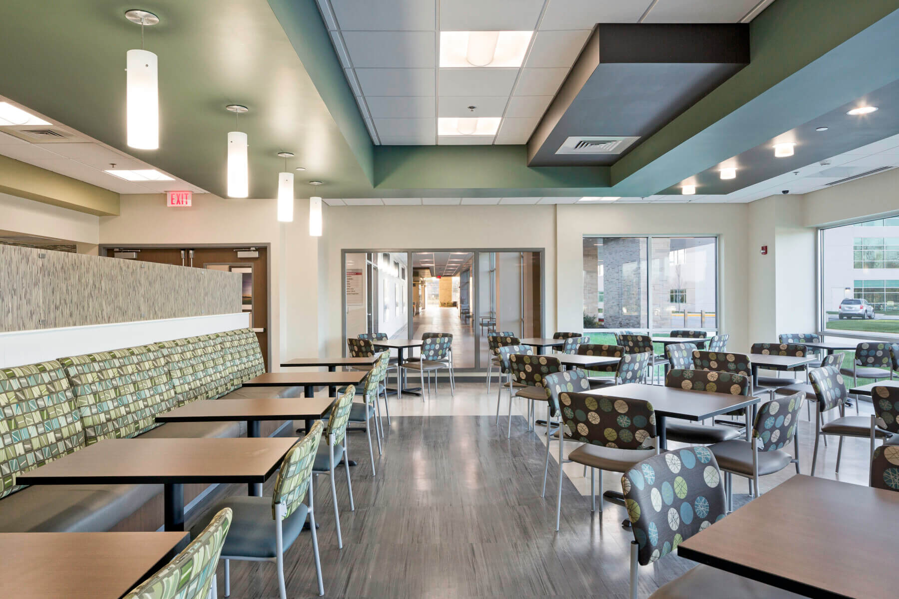 visitors’ dining area with tables chairs, and booths with green and brown decor