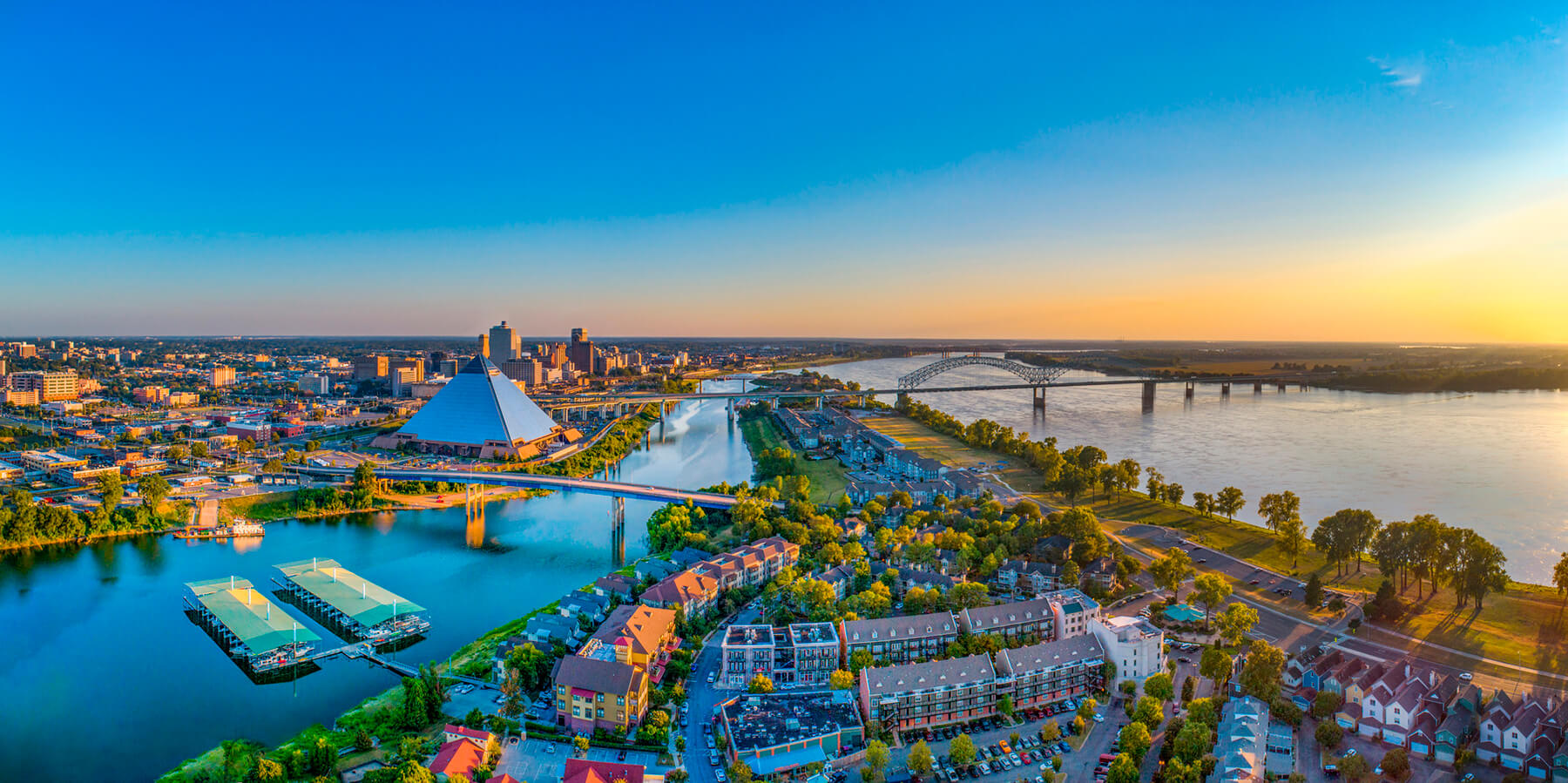 An aerial view of downtown Memphis showing the Memphis Pyramid and the Mississippi River.