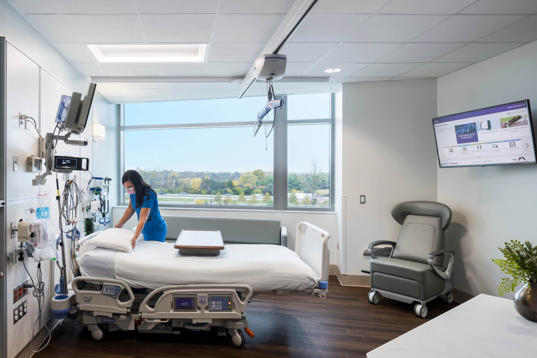 a nurse making a bed in a patient room