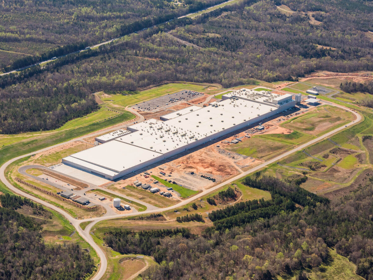 birds-eye-view of the unfinished plant with surrounding acreage of trees and roads