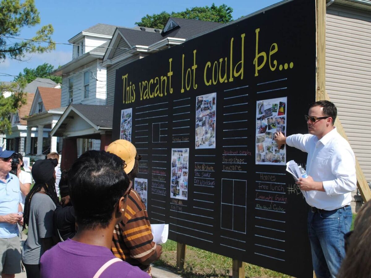 a man pointing to a sign for community engagement