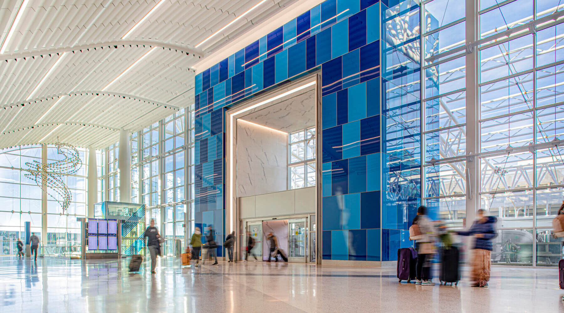 the blue glass-clad entrance to Charlotte Douglas International Airport’s terminal lobby