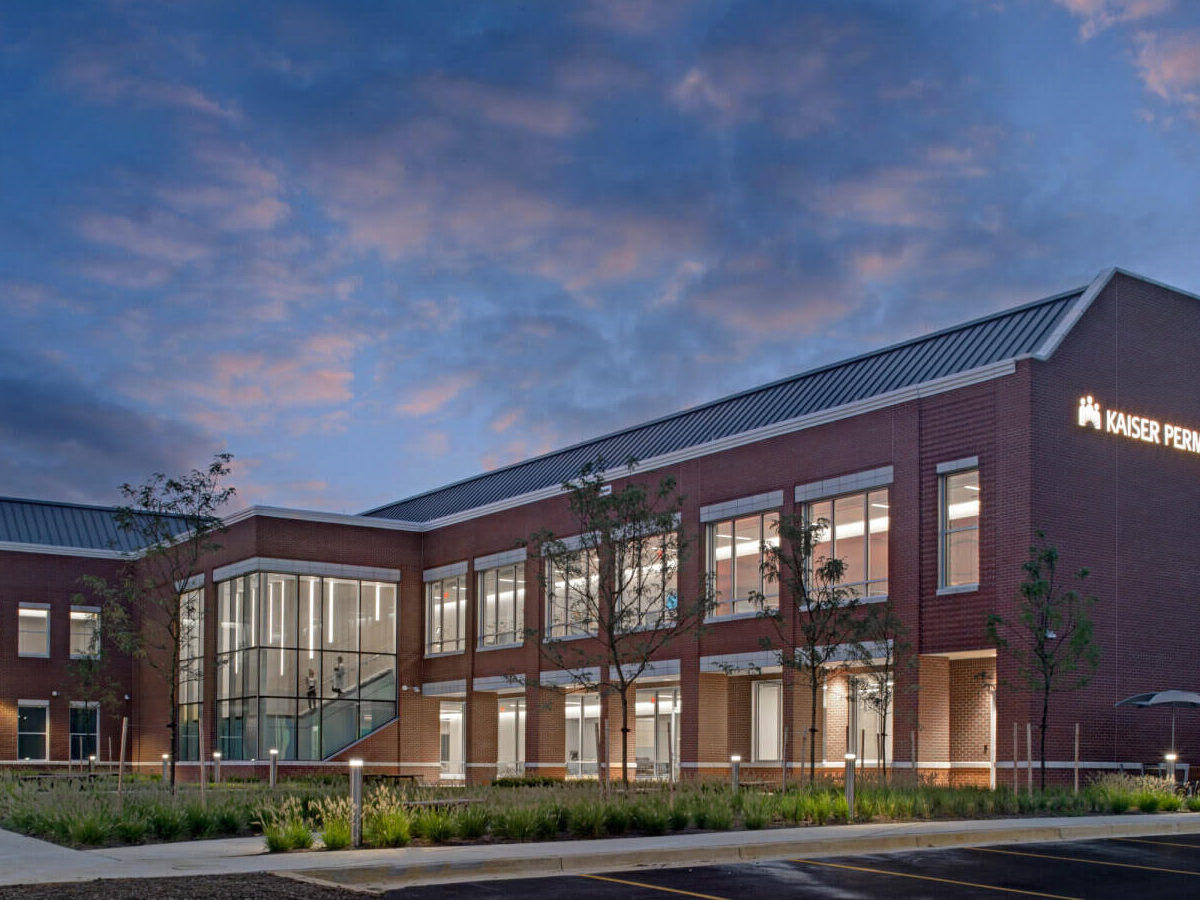 exterior of facility at dusk with sunset in the background and lights on in the building