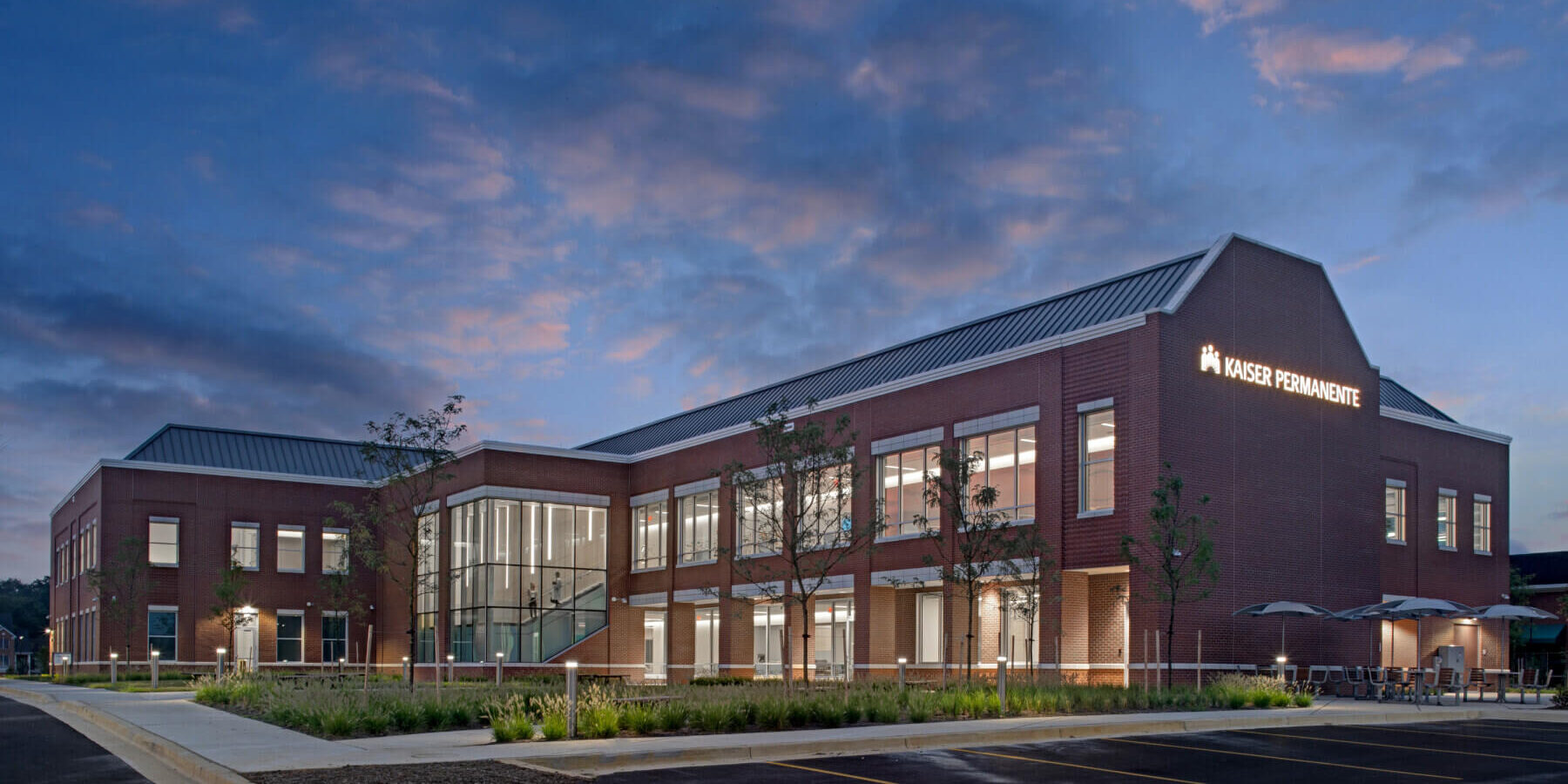 exterior of facility at dusk with sunset in the background and lights on in the building