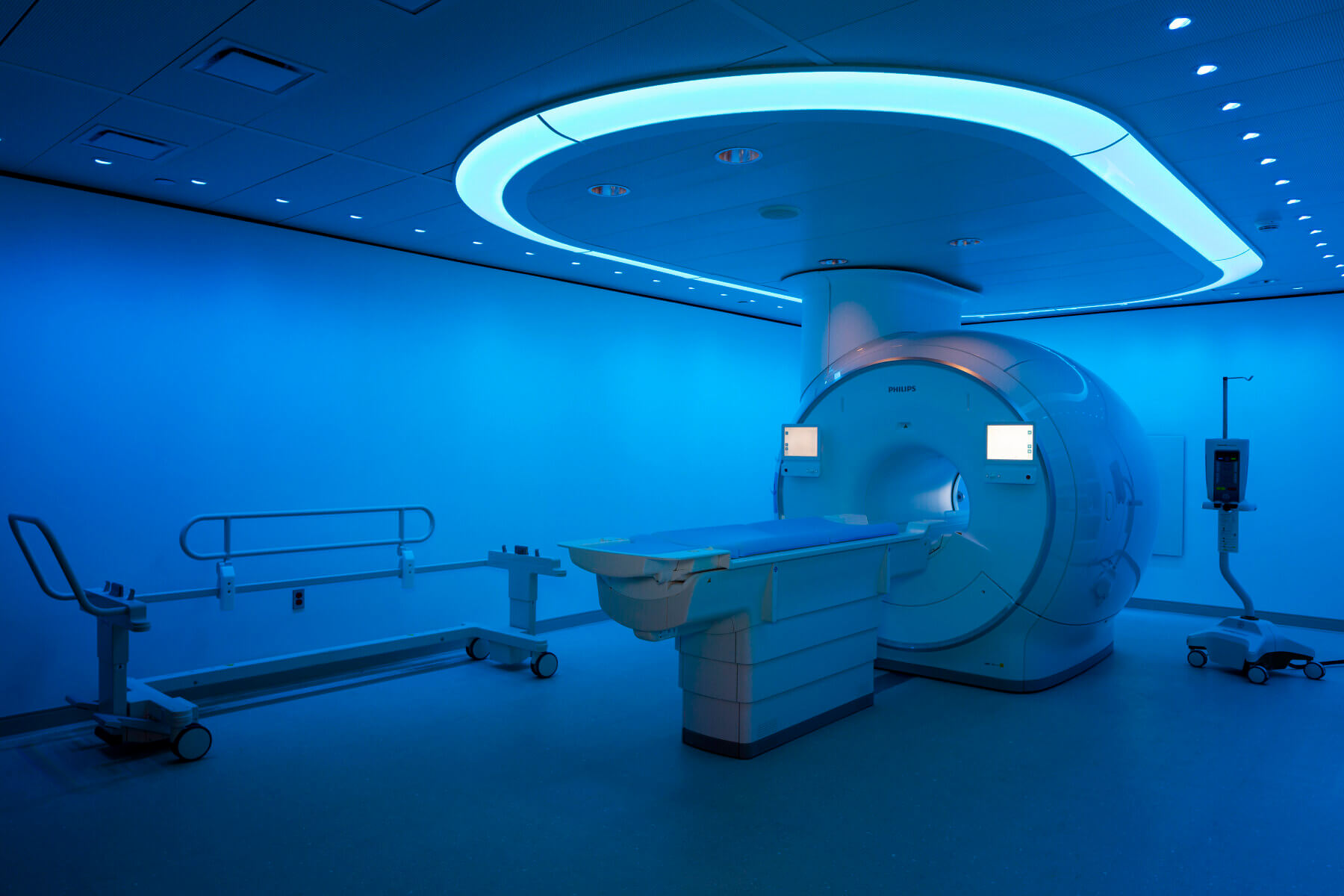 CAT scan machine in the center of a room with vibrant blue lighting