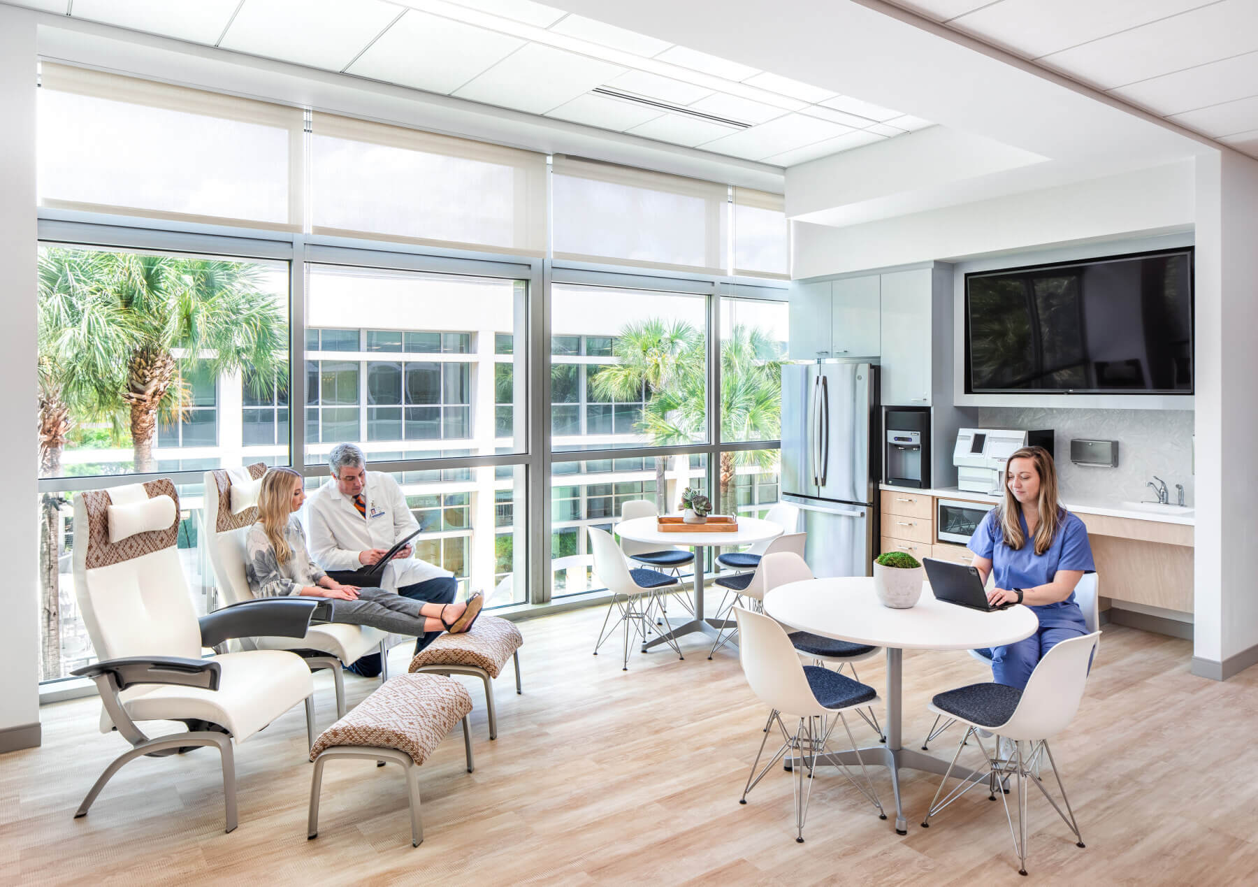 a nurse, doctor and patient sitting near the kitchen