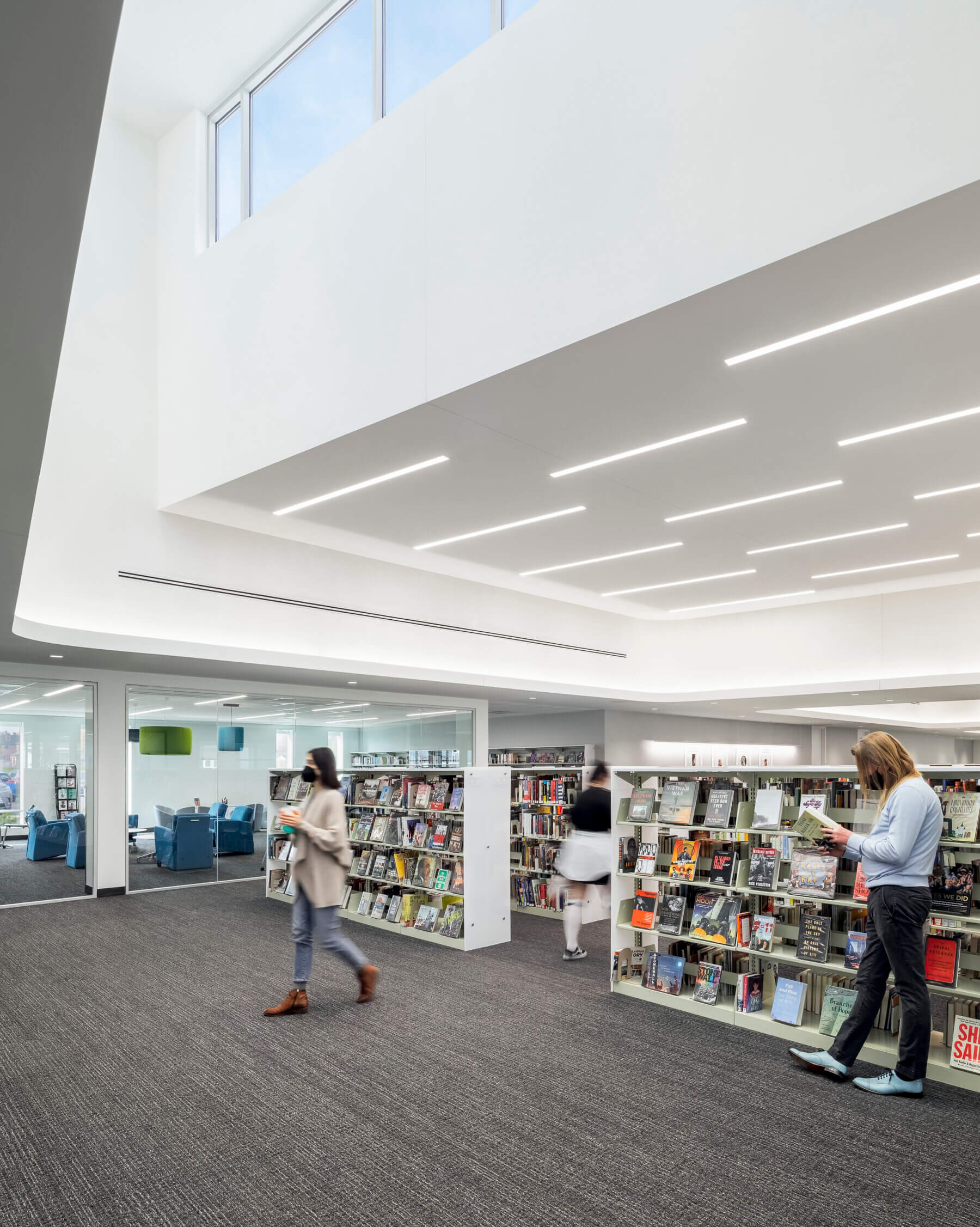 adults reading and walking through the aisles of books