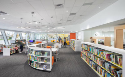 children’s books section with young children and parents browsing the books and reading at children’s tables