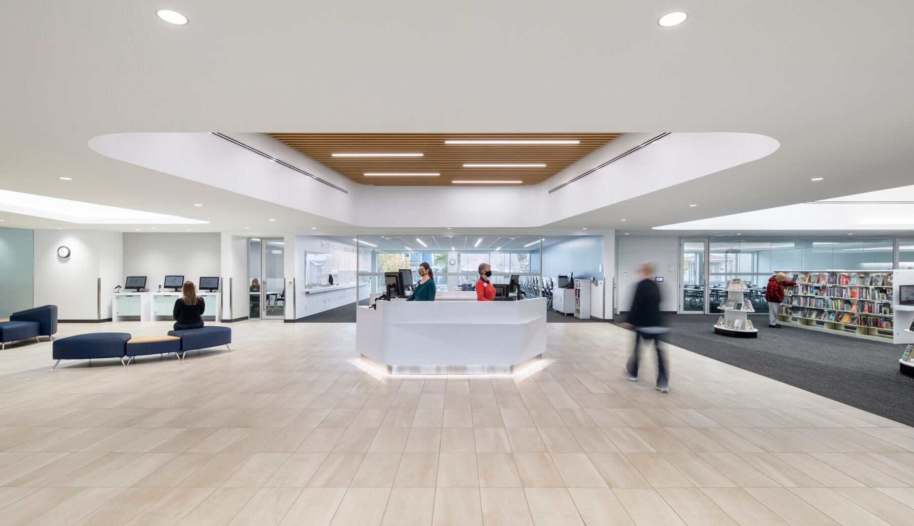 view of the front reception desk with people browsing books in the background