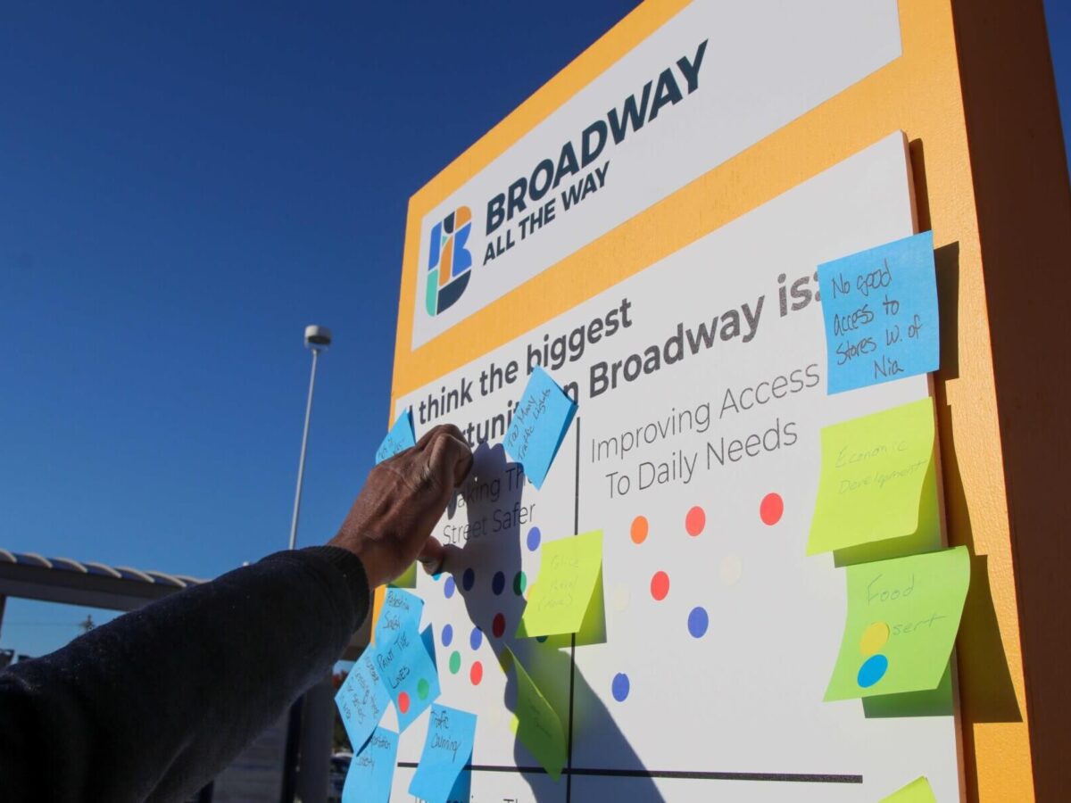 a hand placing a sticky note on a community engagement activity