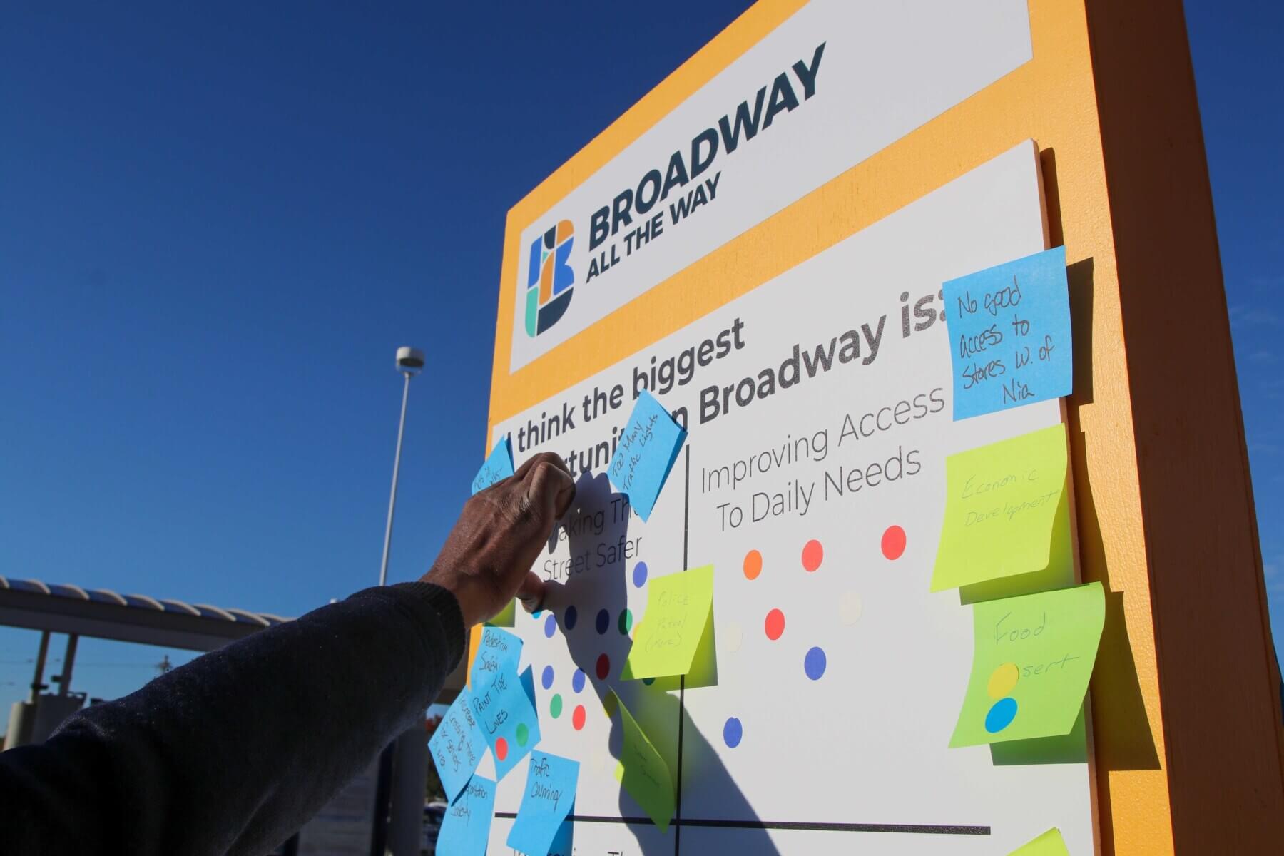 a hand placing a sticky note on a community engagement activity