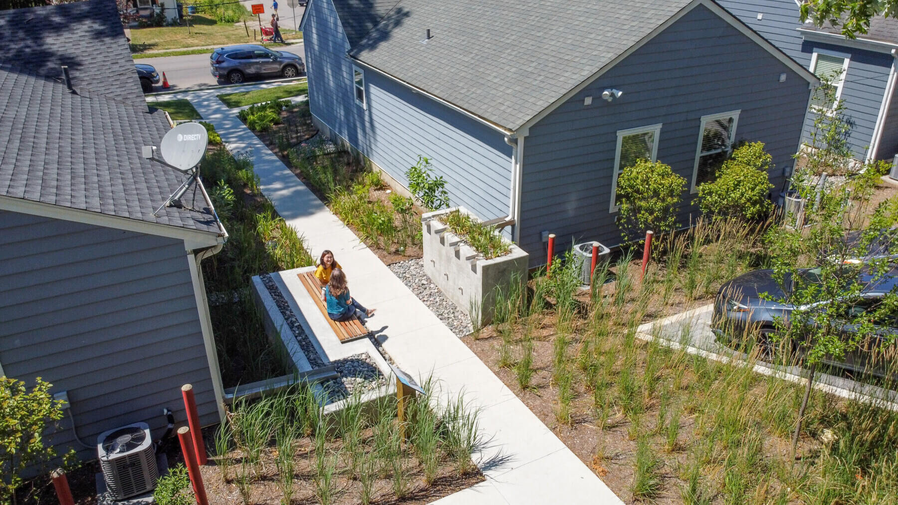 a drone shot of people sitting on a raised bioswale at the Gardens at 900 Block