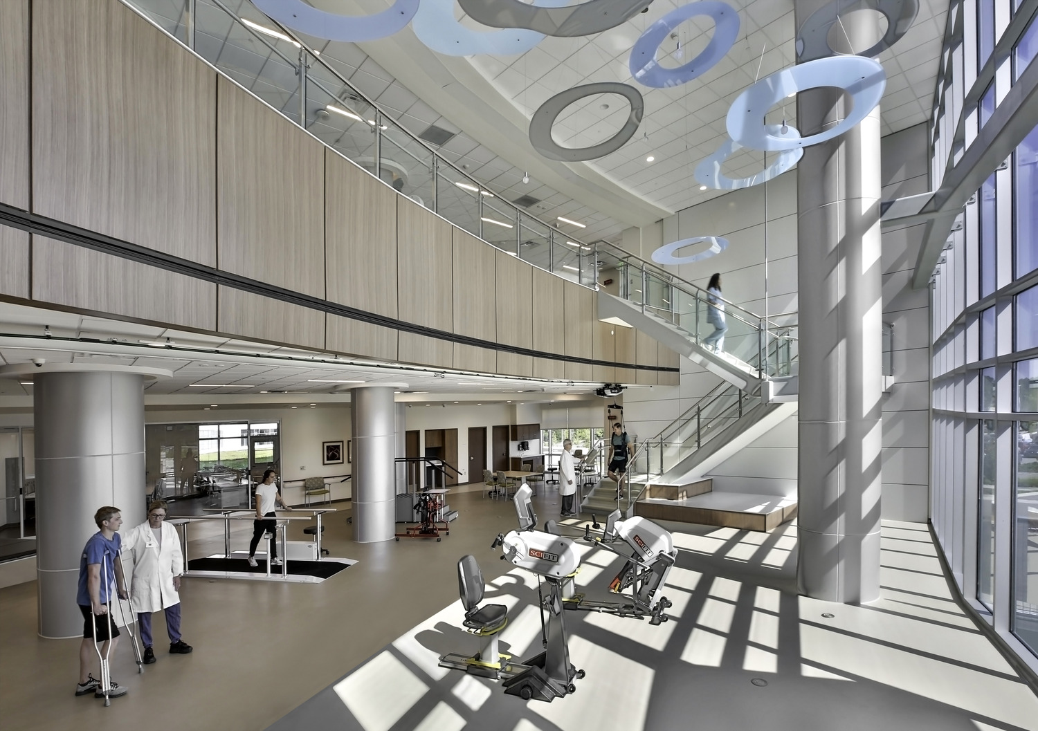 Patients and doctors in a two story rehabilitation gym
