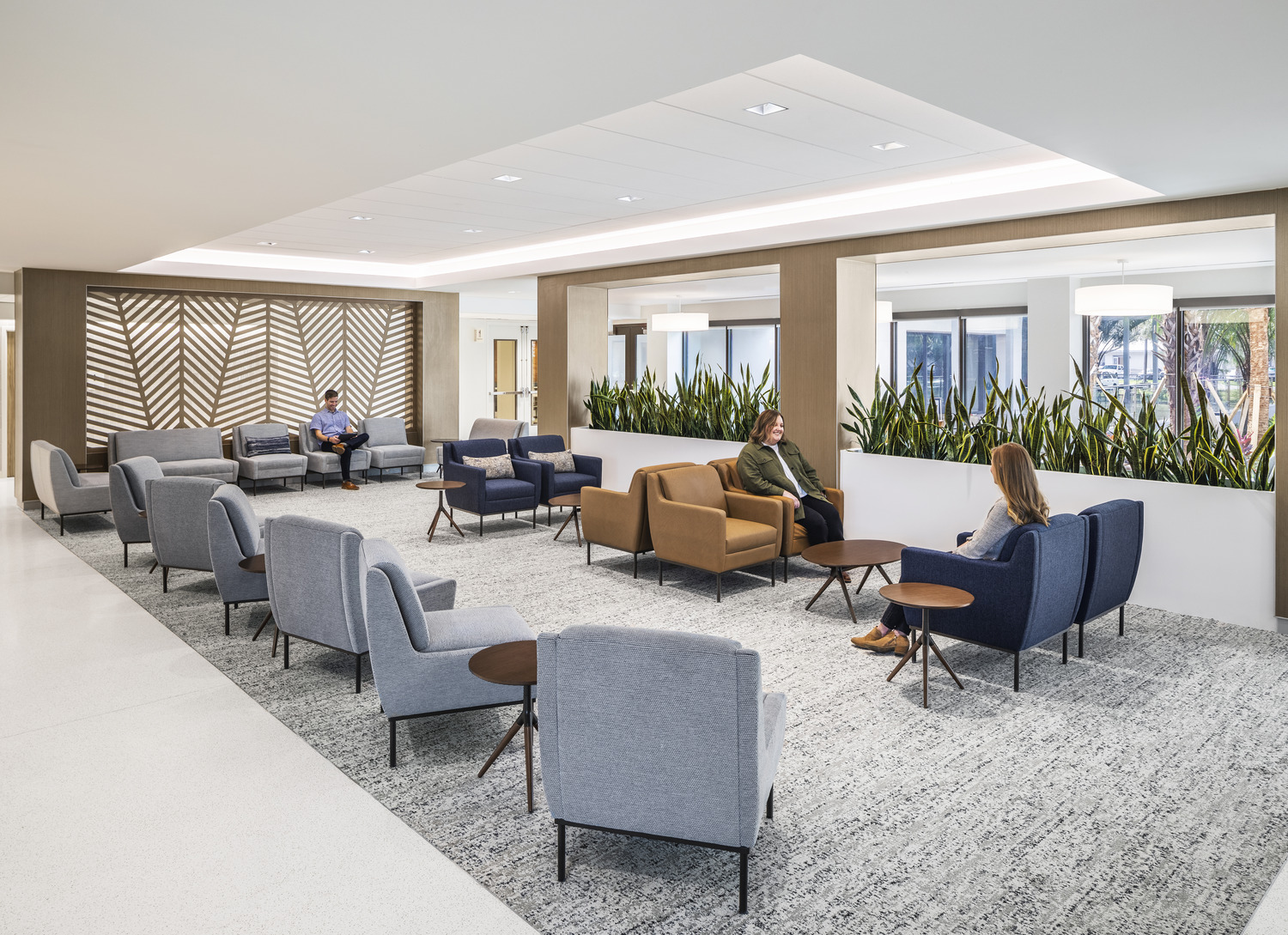 People sitting on couches and chairs in a hospital waiting area