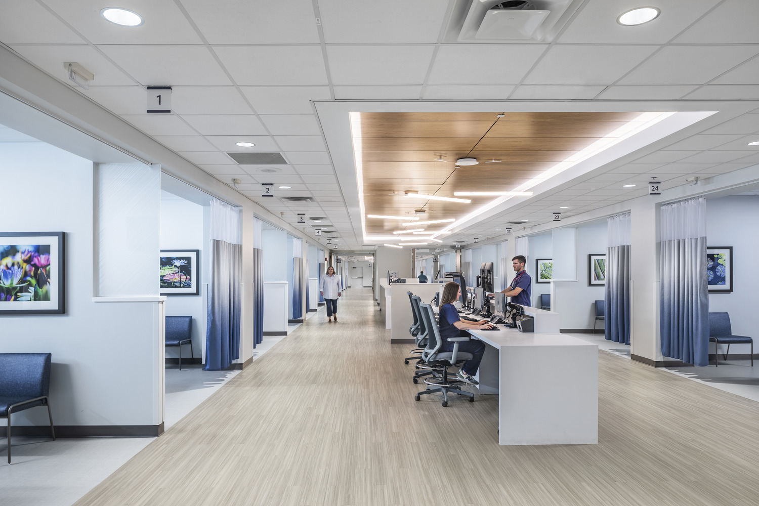 Nurses at a nurse station with patient bays on both sides