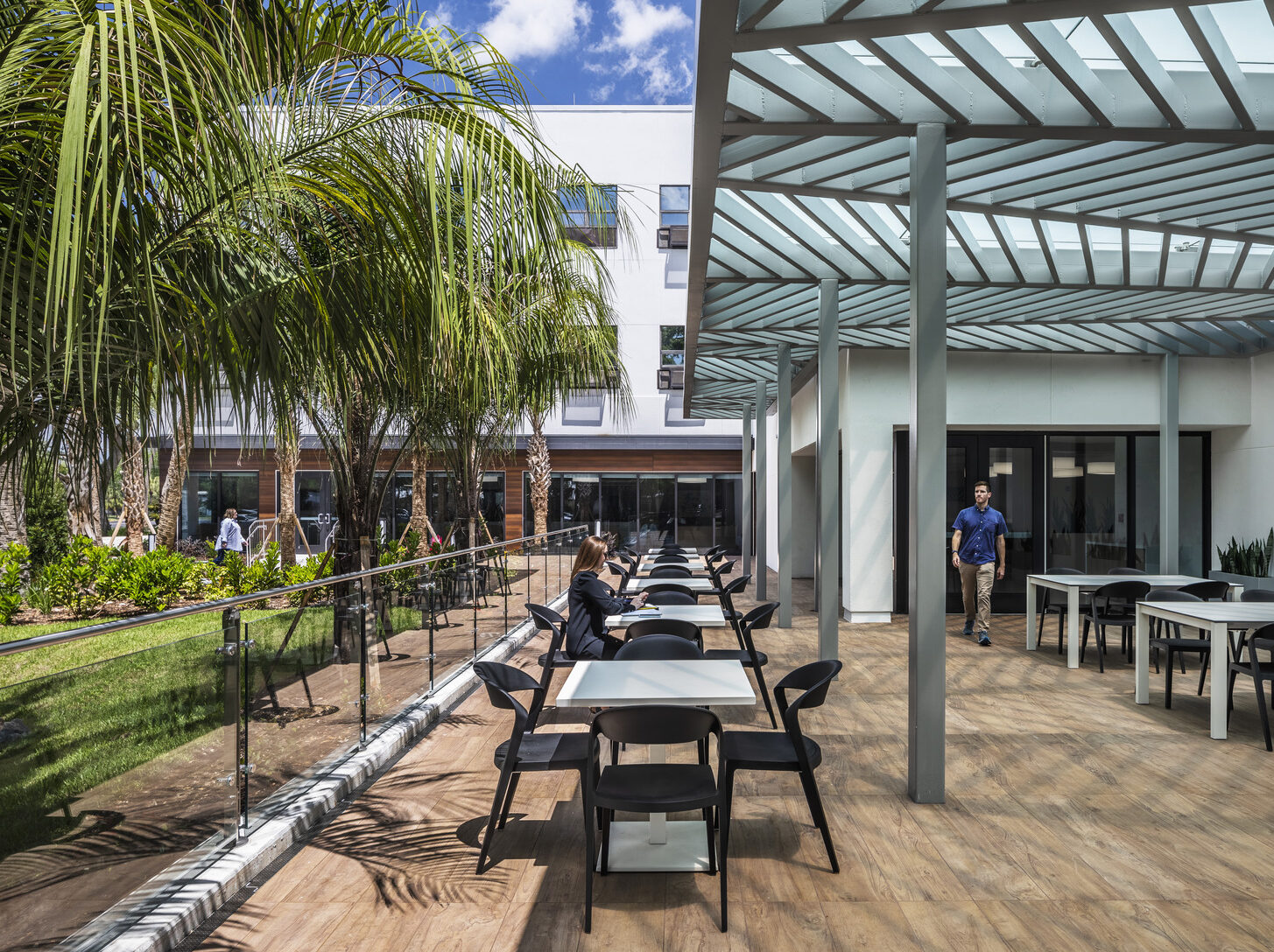 A person sitting at a table on an outdoor patio