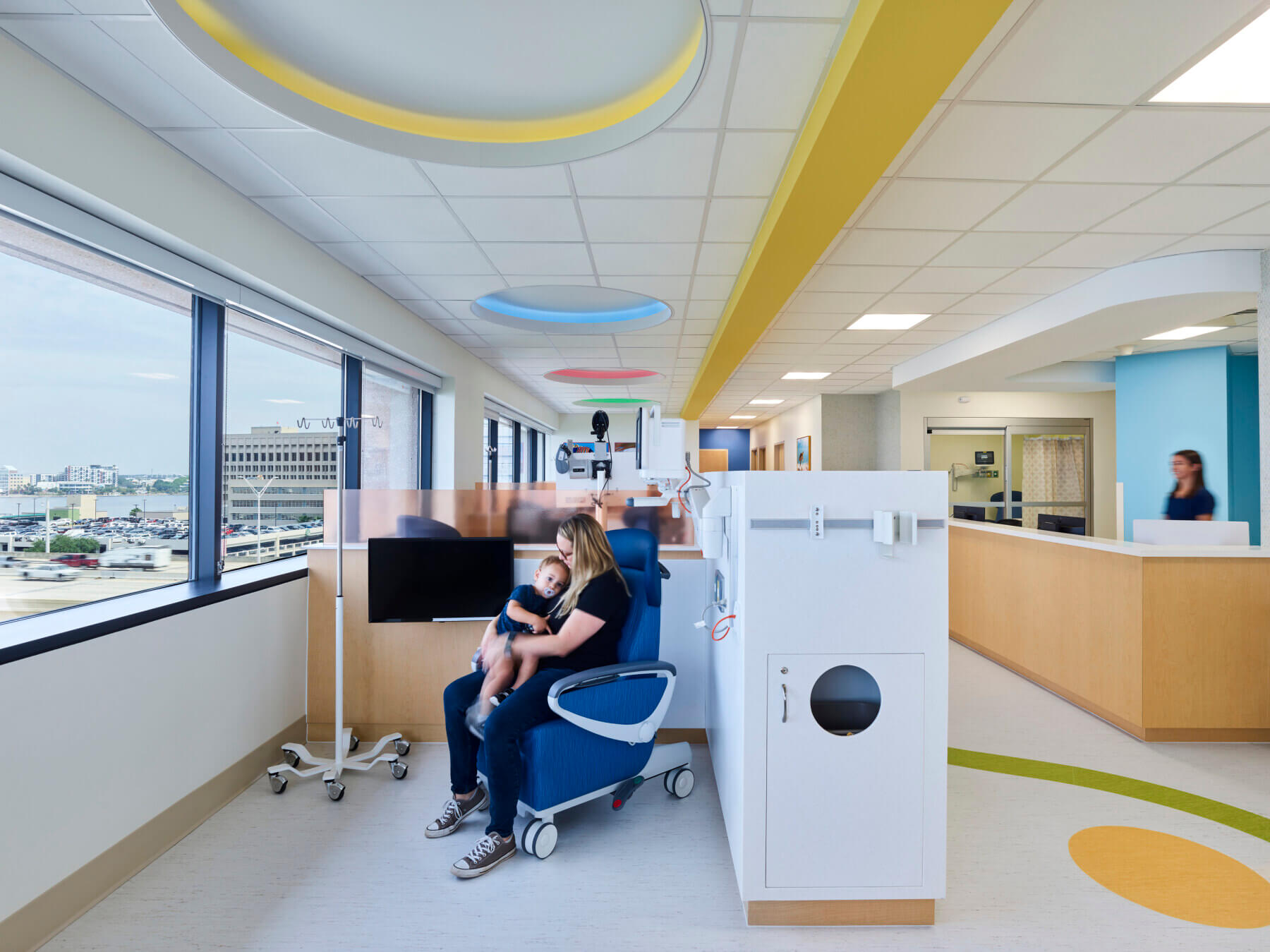 a woman holding a child in an infusion bay