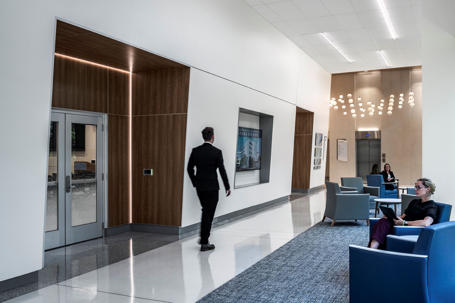 a person walking down a hallway and past a door