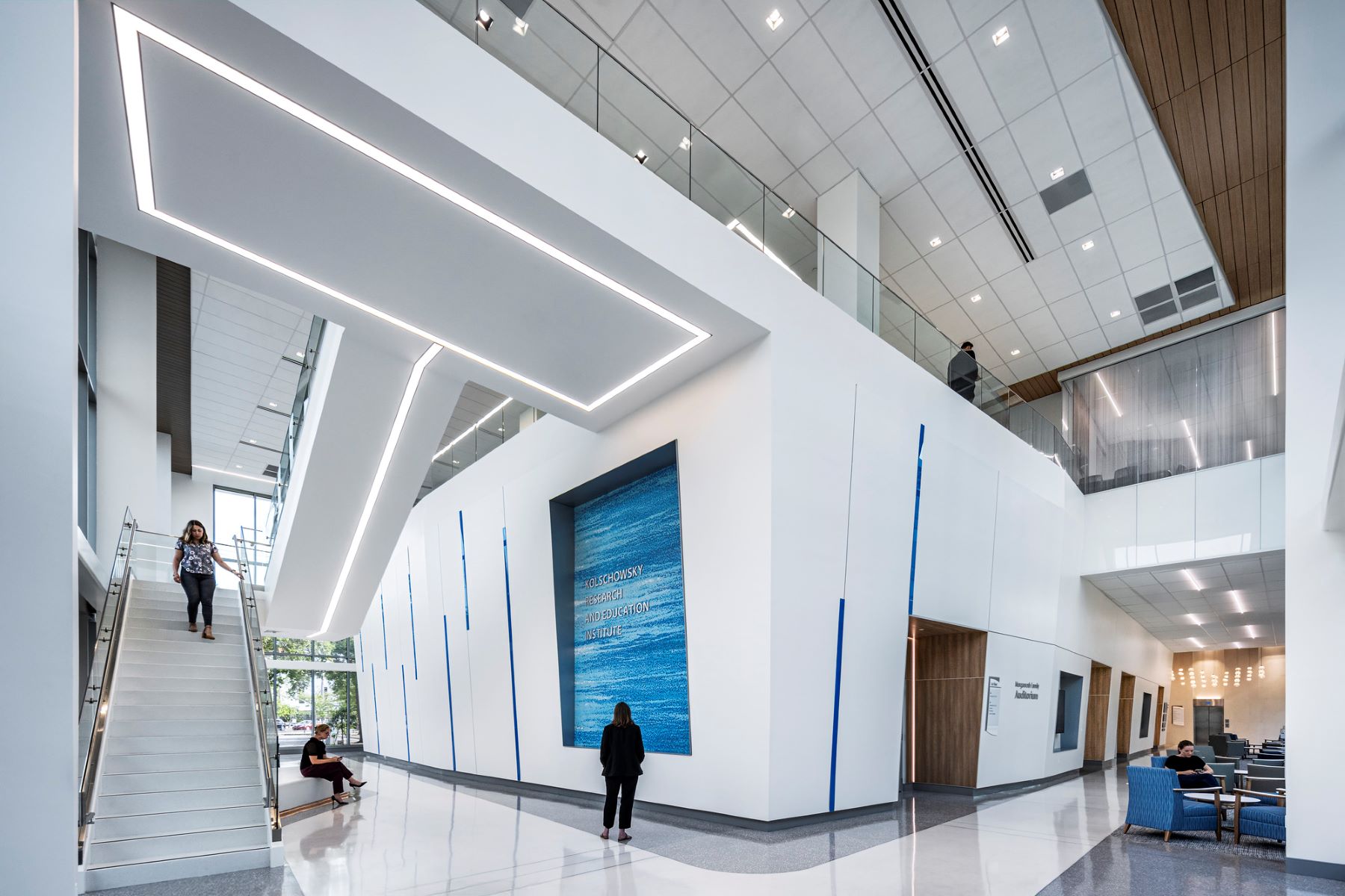 a two-story lobby featuring a large blue mural and a monumental stair
