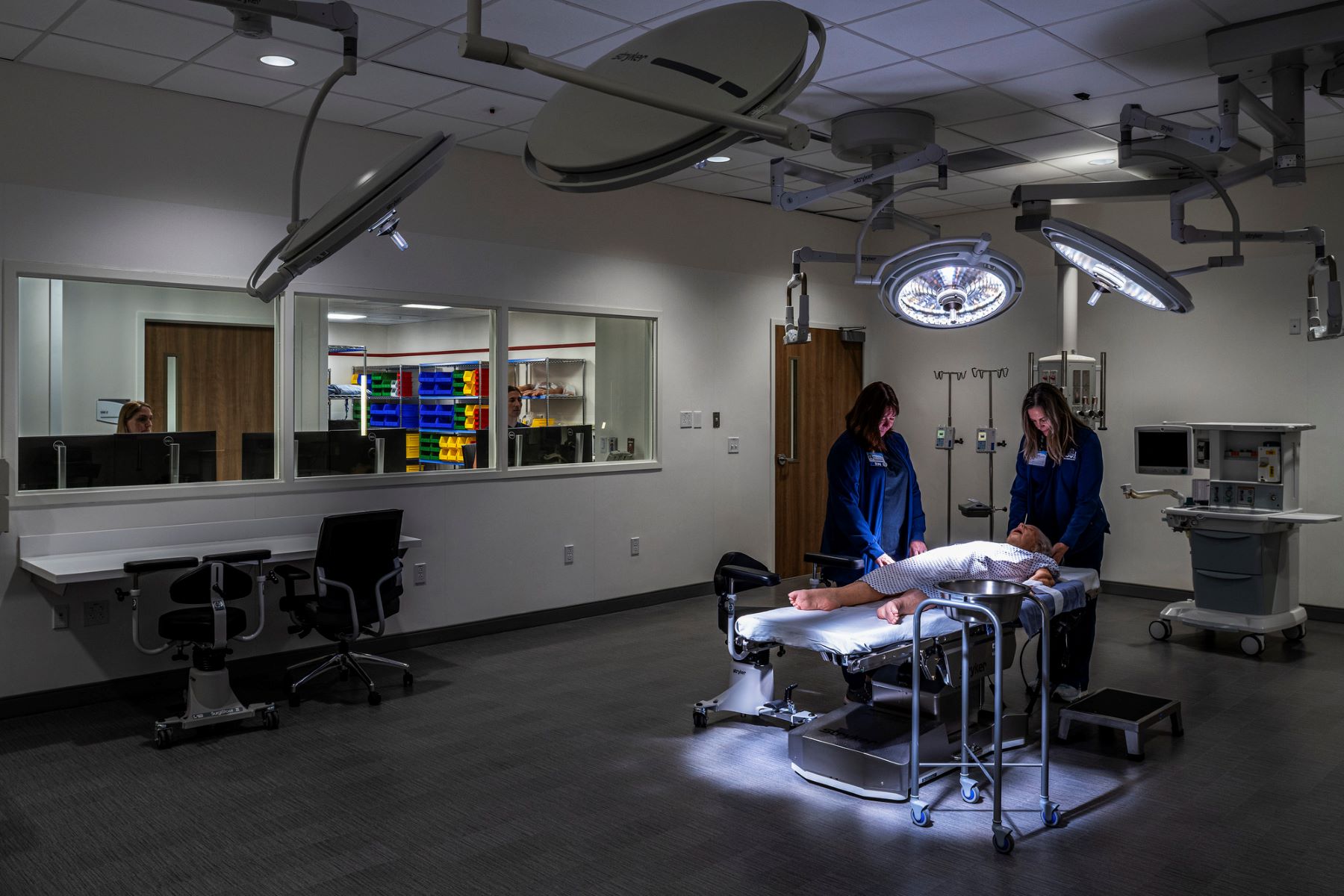two medical students working on a simulation patient in a practice operating room