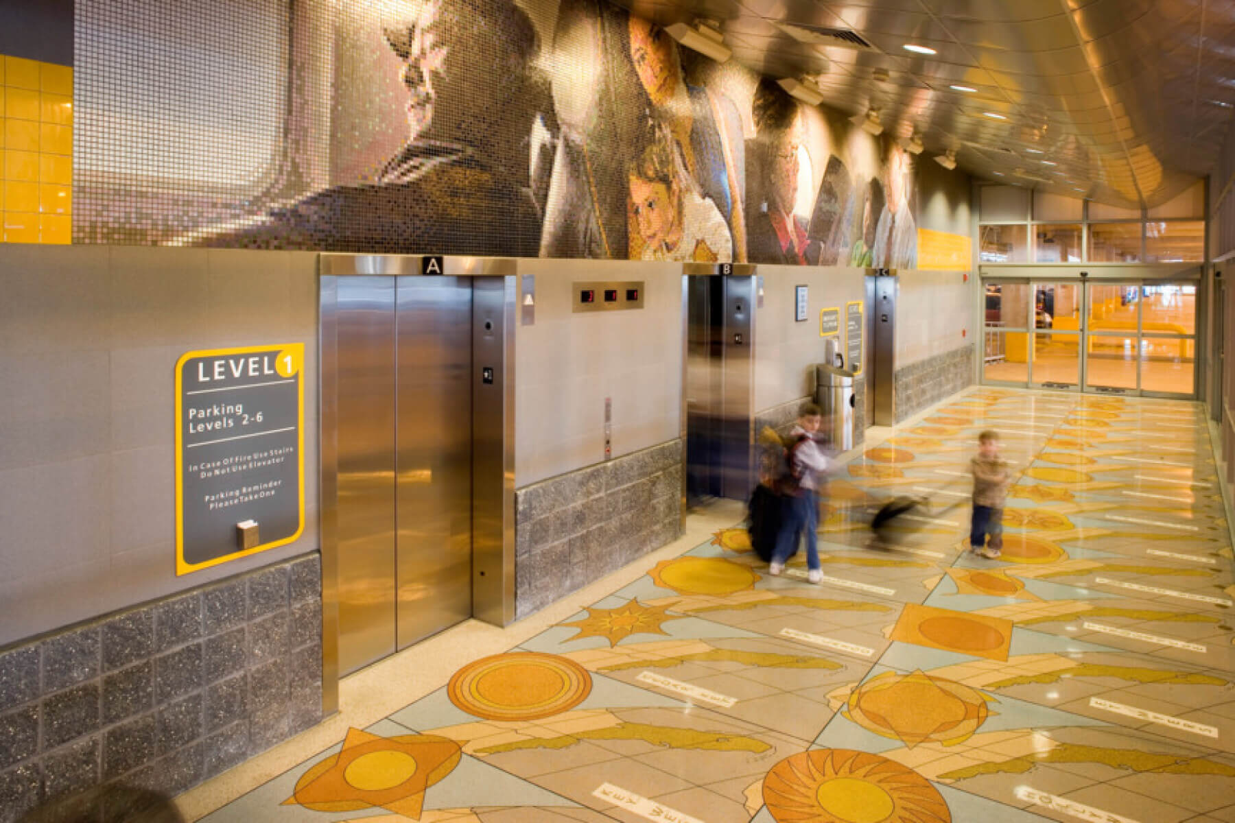 children inside the elevator lobby in the economy parking garage at Tampa International Airport at night