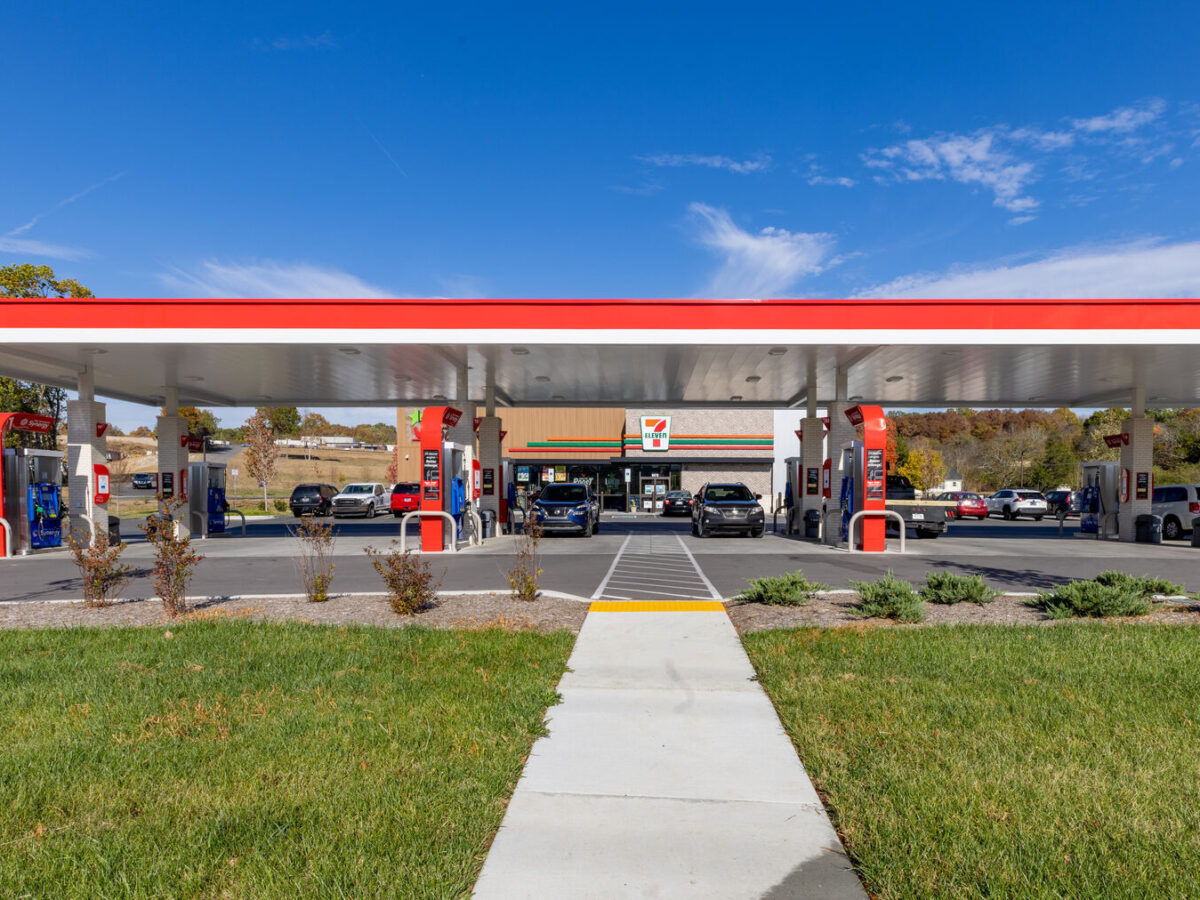 A 7-Eleven gas station with grass and landscape in front