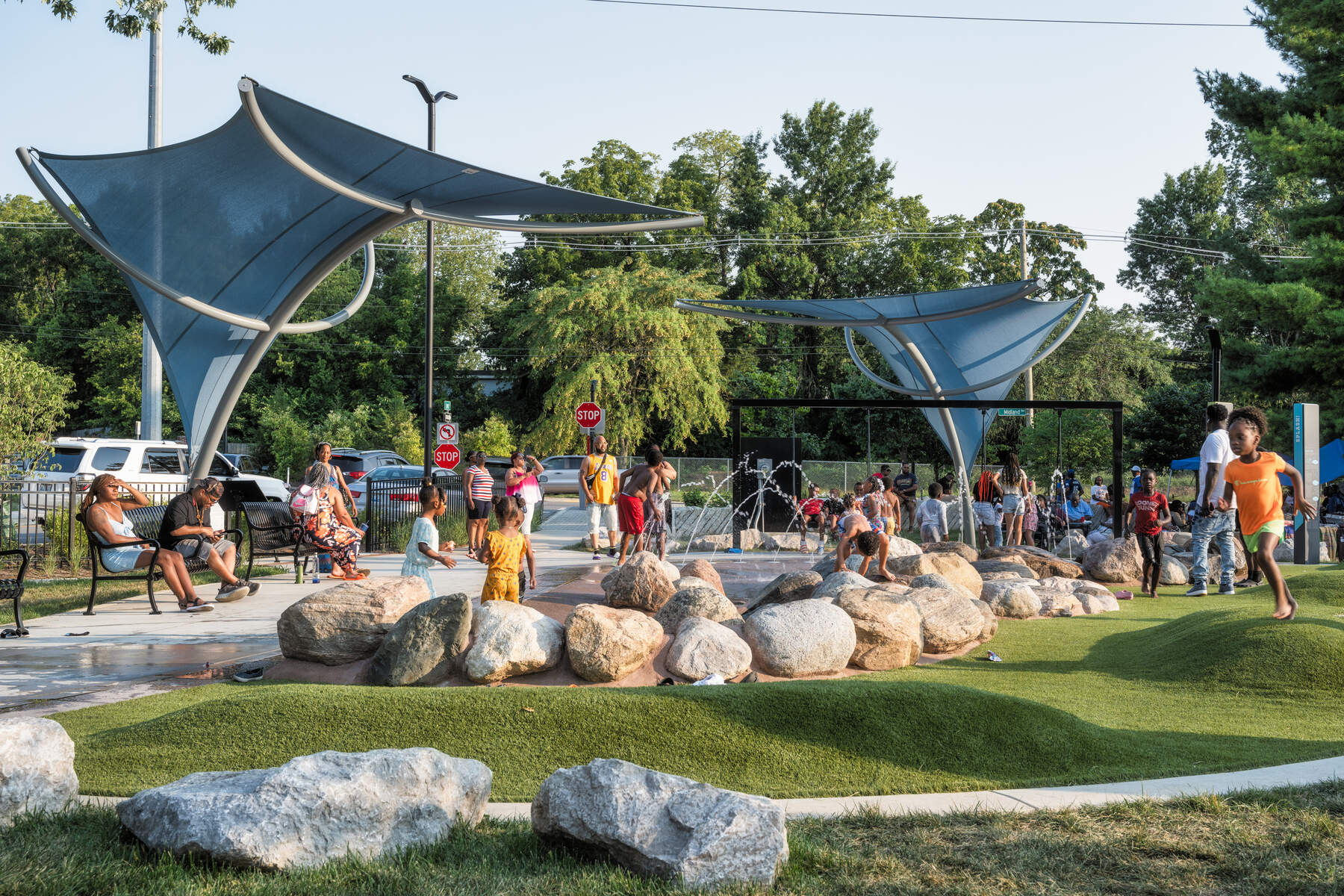 Children playing at a park with rocks and fountains