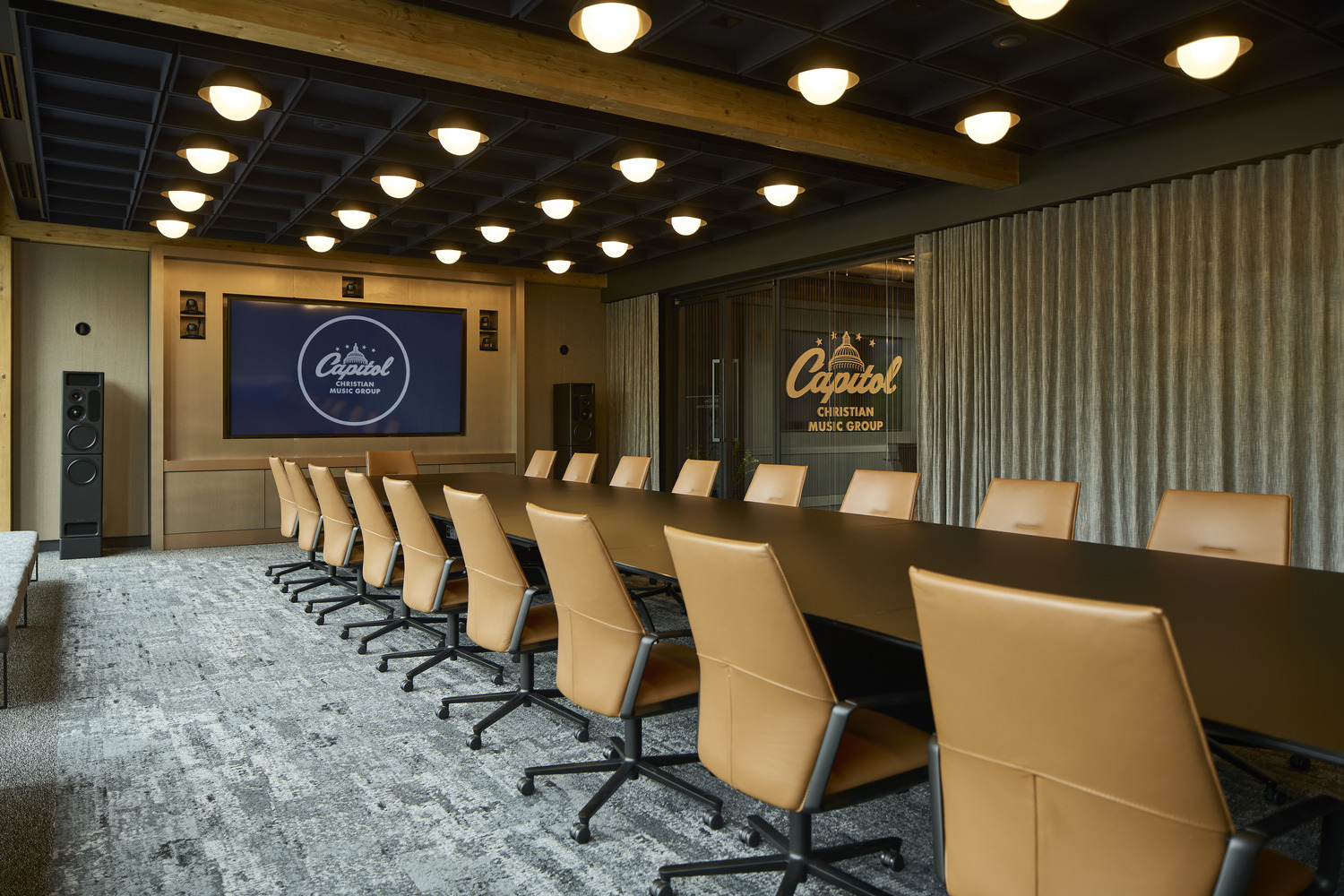A large conference room with a wood table and leather chairs