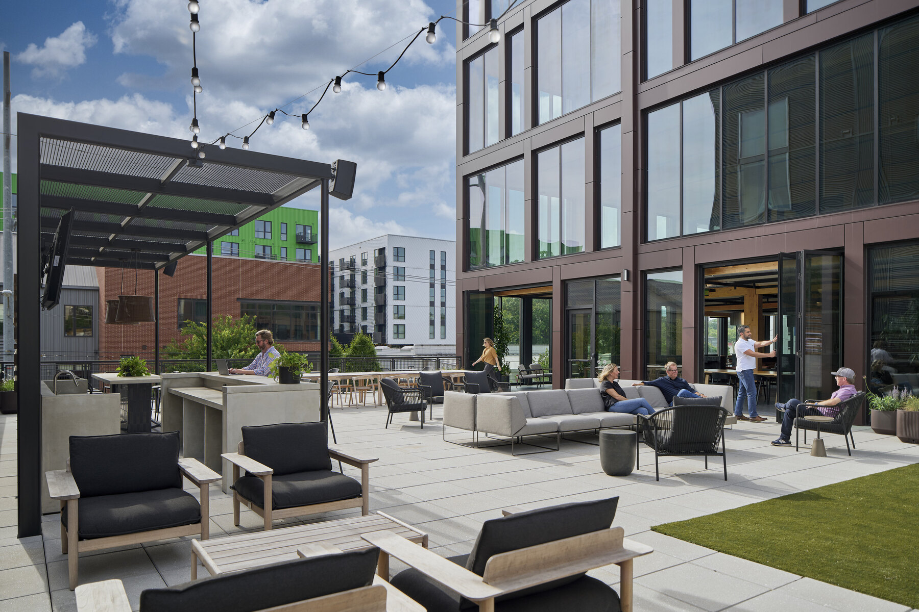 people working at outdoor terrace in various seating areas