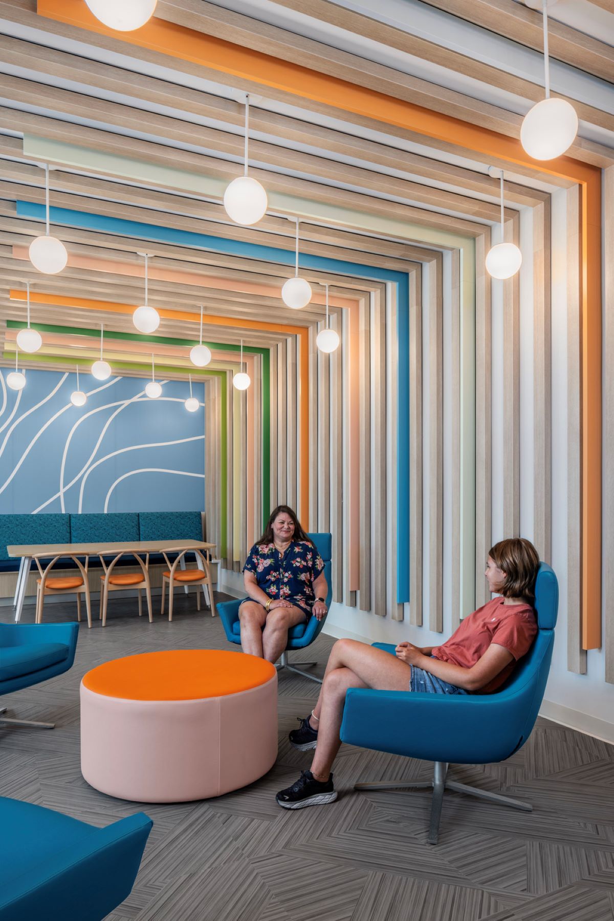 two adults sitting in chairs next in a hospital waiting area