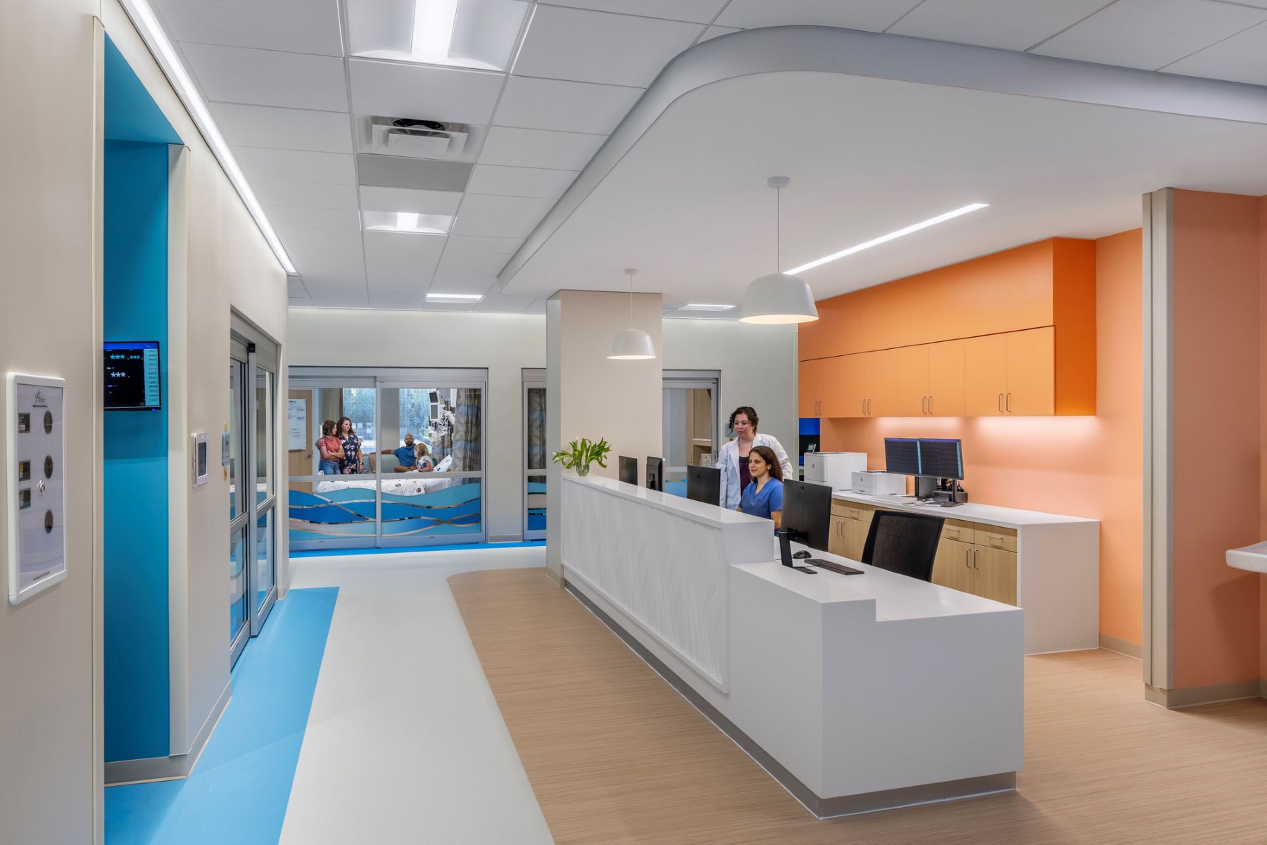 a doctor and a nurse standing behind a nursing station