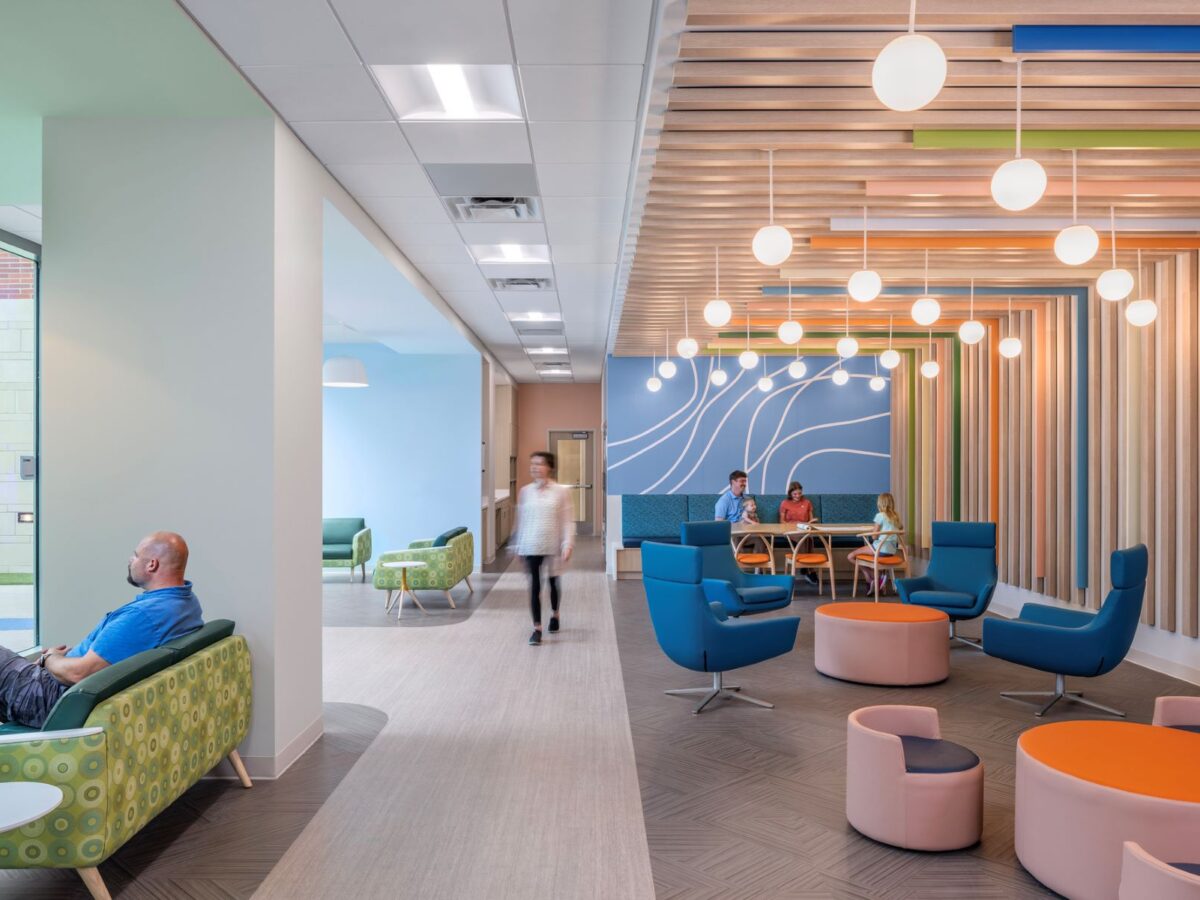 adults sitting in various seating areas in a hospital waiting room