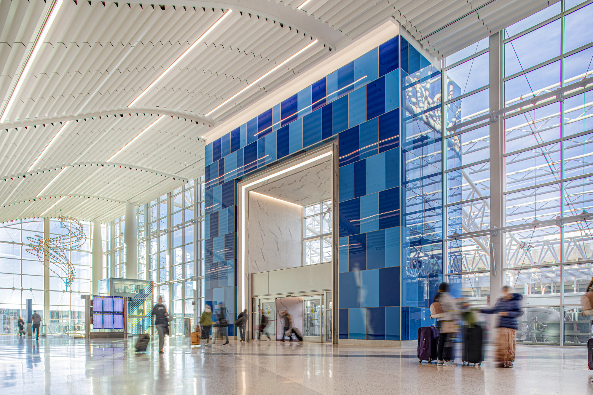 travelers walking through the terminal lobby at Charlotte Douglas International Airport