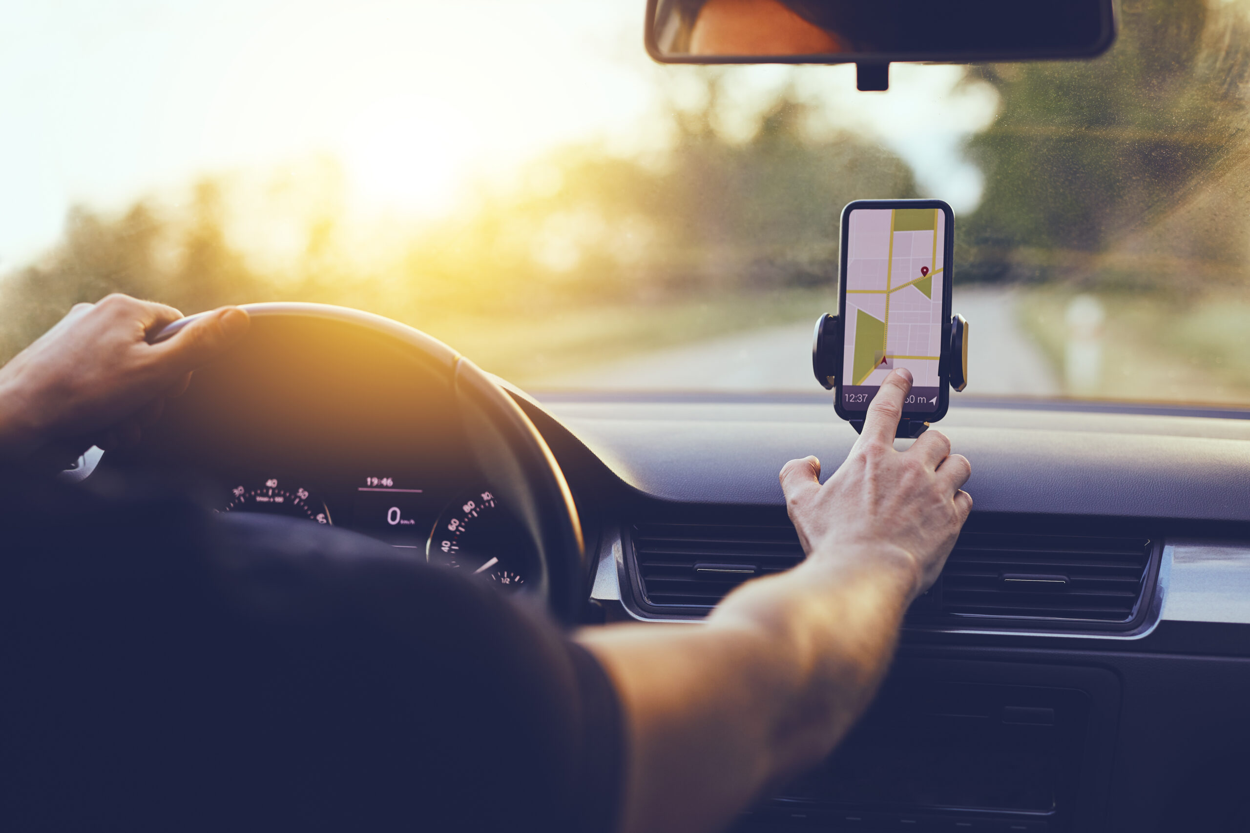 Driver using GPS navigation in mobile phone while driving car.